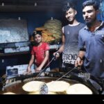 A Bihari chef preparing traditional food in a small local kitchen, reflecting skilled craftsmanship within an under-resourced community in Bangladesh.